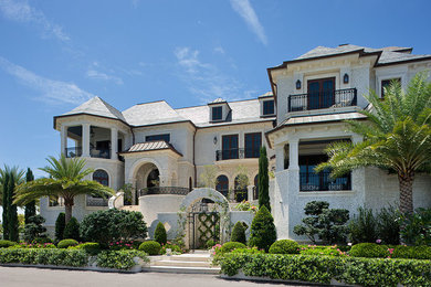 Foto de fachada de casa beige extra grande de tres plantas con revestimiento de piedra y tejado de teja de madera