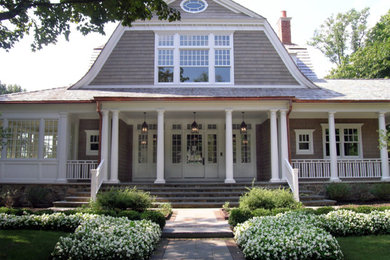 Ejemplo de fachada de casa beige clásica grande de dos plantas con revestimientos combinados, tejado a doble faldón y tejado de teja de madera