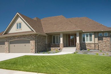 Photo of a large and beige traditional bungalow house exterior in Minneapolis with mixed cladding and a hip roof.