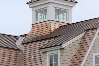 Inspiration for a small coastal gray two-story wood exterior home remodel in Other with a gambrel roof and a mixed material roof