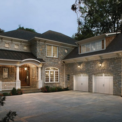 Inspiration for a large timeless beige two-story stone exterior home remodel in Cleveland with a hip roof