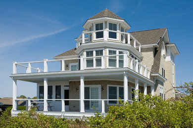 Large beach style beige three-story wood exterior home photo in Providence with a shingle roof