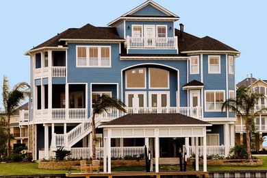 Idee per la facciata di una casa grande blu stile marinaro a tre piani con rivestimento con lastre in cemento e tetto a padiglione