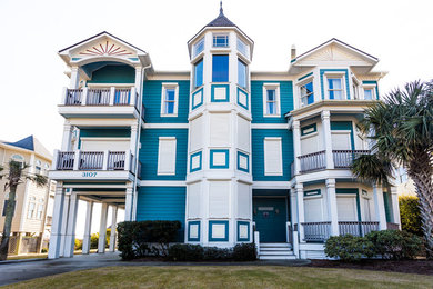 This is an example of a large and blue coastal two floor detached house in Other with wood cladding, a pitched roof and a shingle roof.