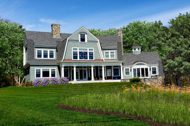 Example of a large beach style green two-story wood house exterior design in Boston with a gambrel roof and a shingle roof