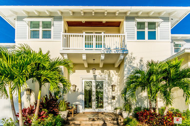 Island style beige two-story exterior home photo in Miami