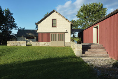 Exemple d'une façade de maison grise chic en bois de taille moyenne et à un étage avec un toit en appentis.