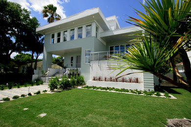Ejemplo de fachada de casa blanca moderna de tamaño medio a niveles con revestimientos combinados y tejado plano