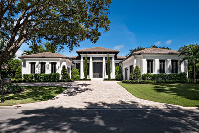 Mid-sized transitional one-story house exterior idea in Miami with a hip roof and a tile roof