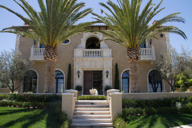 Example of a huge tuscan yellow three-story stucco exterior home design in Orange County