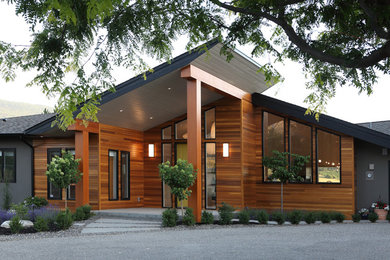 Example of a trendy brown one-story stucco exterior home design in Vancouver with a shingle roof