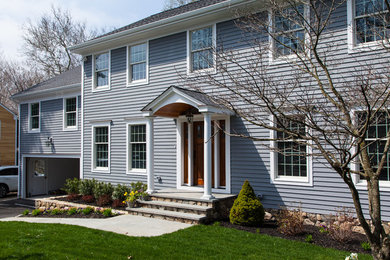 Large transitional blue two-story wood exterior home photo in New York with a shingle roof