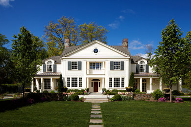Imagen de fachada de casa blanca clásica de dos plantas con tejado a dos aguas