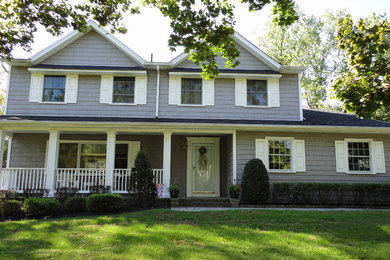 Cette image montre une façade de maison grise traditionnelle de taille moyenne et à un étage avec un revêtement en vinyle, un toit à deux pans et un toit en shingle.