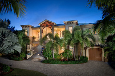 マイアミにあるラグジュアリーな巨大なトロピカルスタイルのおしゃれな家の外観 (漆喰サイディング) の写真