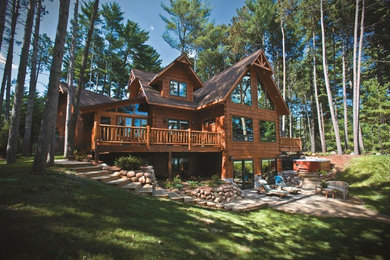 Modelo de fachada marrón rural grande a niveles con revestimiento de madera y tejado a dos aguas