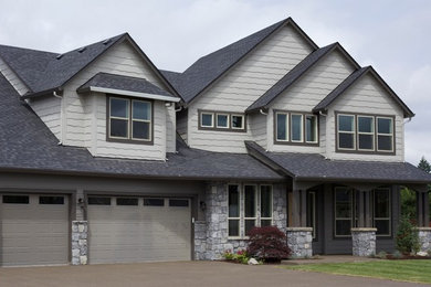 Example of a large trendy beige two-story stone exterior home design in Portland