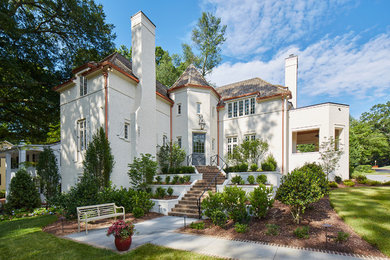 Immagine della facciata di una casa bianca moderna a tre piani con rivestimento in mattoni