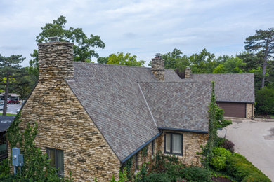 Example of a large multicolored one-story stone exterior home design in Kansas City with a shingle roof