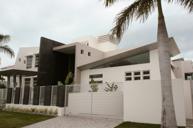 Foto de fachada de casa blanca moderna grande de tres plantas con revestimiento de hormigón, tejado plano y tejado de metal