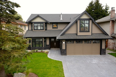 Large traditional beige two-story stone exterior home idea in Vancouver with a shingle roof