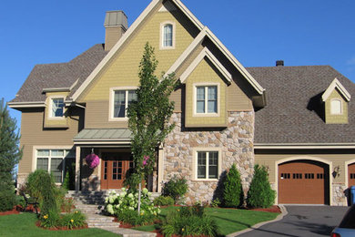 Example of a large brown three-story stone gable roof design in Montreal