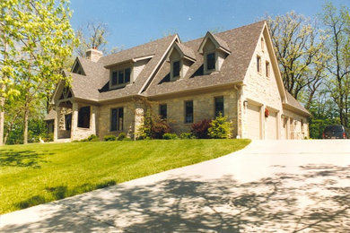 Foto de fachada de casa beige clásica de tamaño medio de dos plantas con revestimiento de piedra y tejado a dos aguas