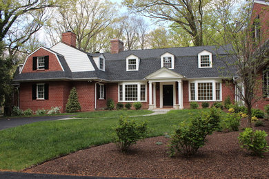 Immagine della facciata di una casa marrone a due piani con rivestimento in mattoni
