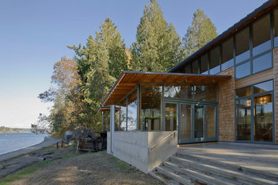 Imagen de fachada marrón grande de una planta con revestimientos combinados y tejado plano