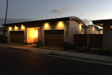 Example of a mid-sized transitional beige one-story stucco flat roof design in Orange County
