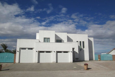 Imagen de fachada blanca moderna de tamaño medio de dos plantas con revestimiento de hormigón y tejado plano