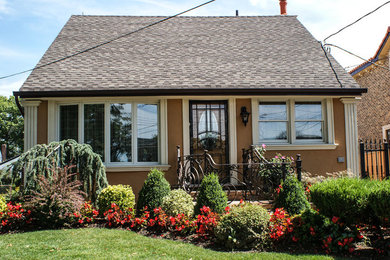 Inspiration for a small timeless brown one-story stucco exterior home remodel in New York with a shingle roof