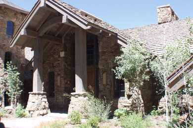 Mid-sized rustic gray two-story mixed siding house exterior idea in Austin with a hip roof and a mixed material roof