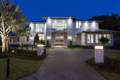 Example of a large trendy white two-story stucco flat roof design in Miami