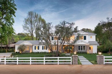 Farmhouse white two-story clapboard exterior home photo in Los Angeles with a shingle roof and a gray roof