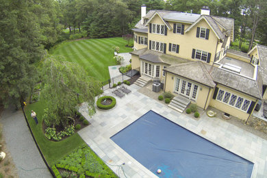 Inspiration for a large timeless yellow three-story vinyl exterior home remodel in Boston with a shingle roof