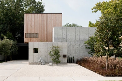 Idée de décoration pour une façade de maison grise minimaliste à un étage avec un revêtement mixte et un toit plat.