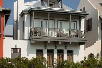 Immagine della facciata di una casa grande bianca stile marinaro a tre piani con rivestimento in stucco e tetto a padiglione