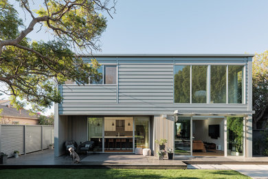 Foto de fachada de casa gris moderna grande de dos plantas con revestimiento de metal, tejado plano y techo verde