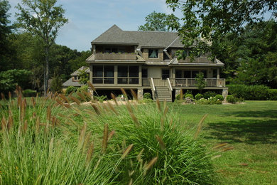 Esempio della villa grande beige american style a due piani con rivestimento in legno, falda a timpano e copertura a scandole