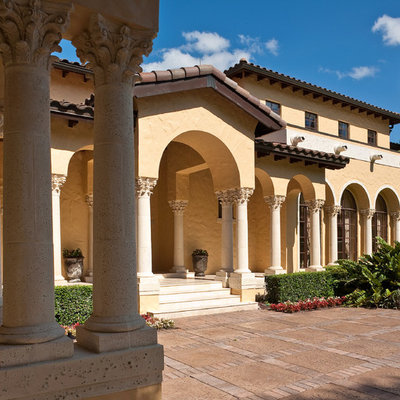 Example of a huge tuscan beige two-story stucco exterior home design in Tampa with a tile roof