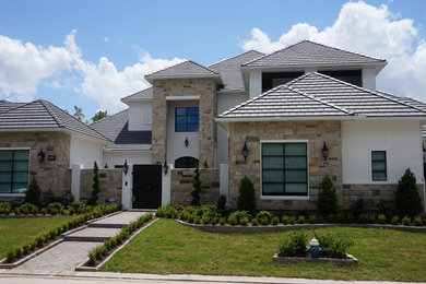 Large contemporary multicolored two-story mixed siding house exterior idea in Houston with a hip roof and a shingle roof