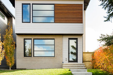 Imagen de fachada de casa blanca contemporánea grande de dos plantas con revestimiento de madera, tejado plano y tejado de metal