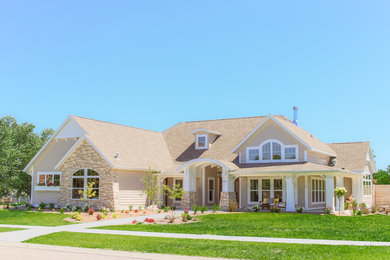 Imagen de fachada de casa beige tradicional grande de dos plantas con revestimiento de vinilo, tejado a dos aguas y tejado de teja de barro
