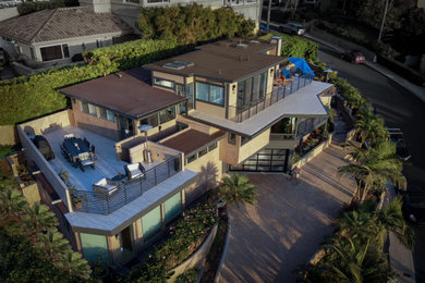 Example of a mid-sized trendy brown three-story stucco exterior home design in San Diego with a green roof