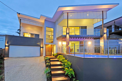 Modelo de fachada de casa multicolor contemporánea extra grande de dos plantas con revestimiento de aglomerado de cemento, tejado a cuatro aguas y tejado de metal