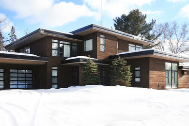 Foto de fachada marrón actual grande de dos plantas con revestimiento de madera y tejado plano