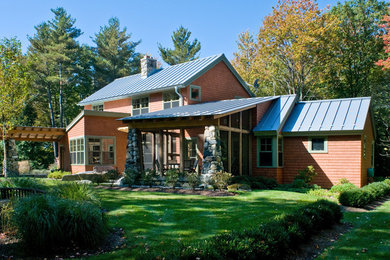 Imagen de fachada de casa roja de estilo americano grande de dos plantas con revestimiento de madera y tejado a la holandesa