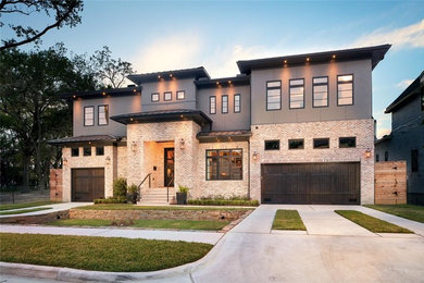 Example of a large trendy gray two-story mixed siding house exterior design in Houston with a hip roof and a metal roof