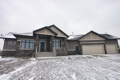 This is an example of a large and gey contemporary bungalow house exterior in Edmonton with mixed cladding.